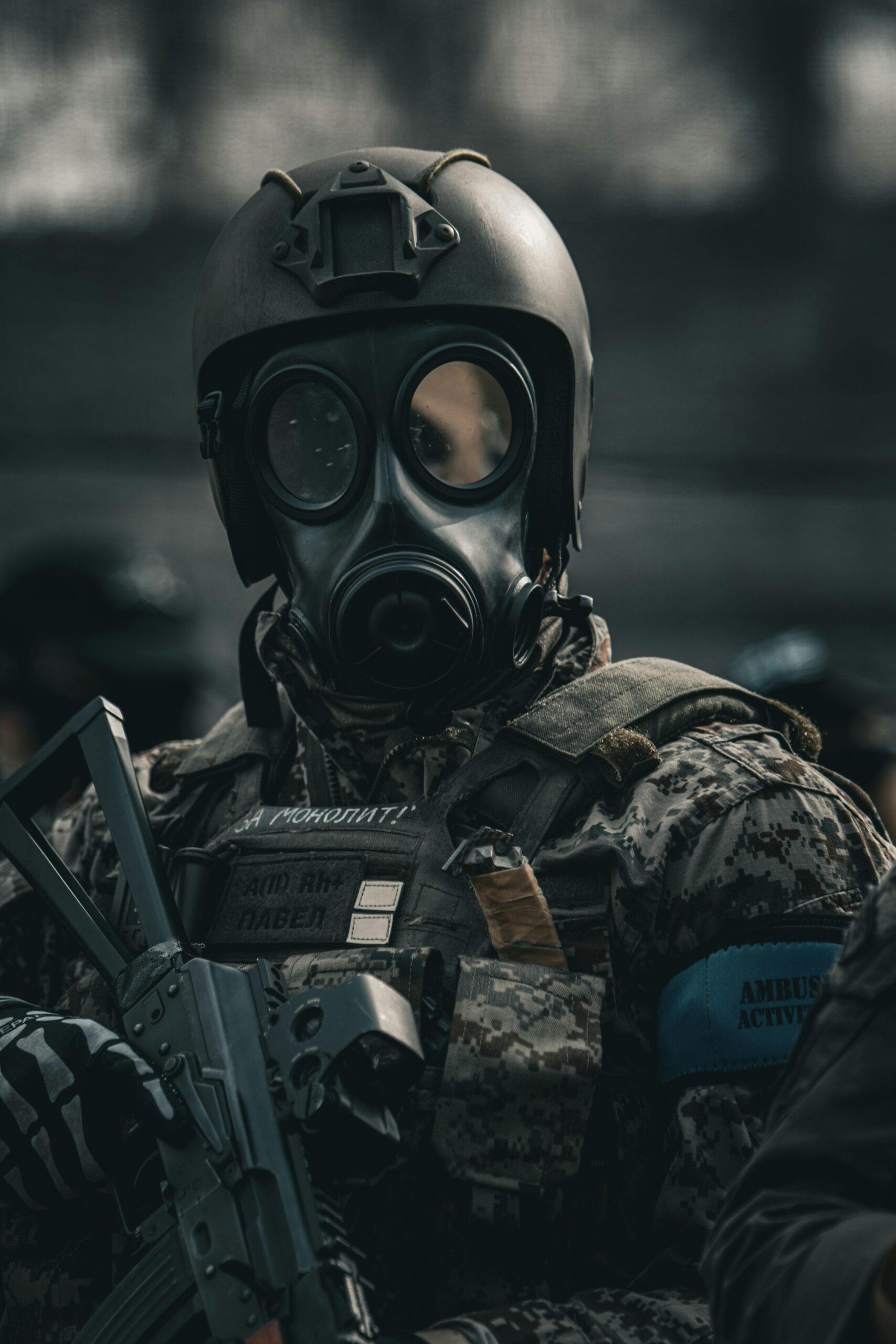 Portrait of a soldier in full uniform wearing a gas mask, holding a weapon, exuding a tense and serious mood.